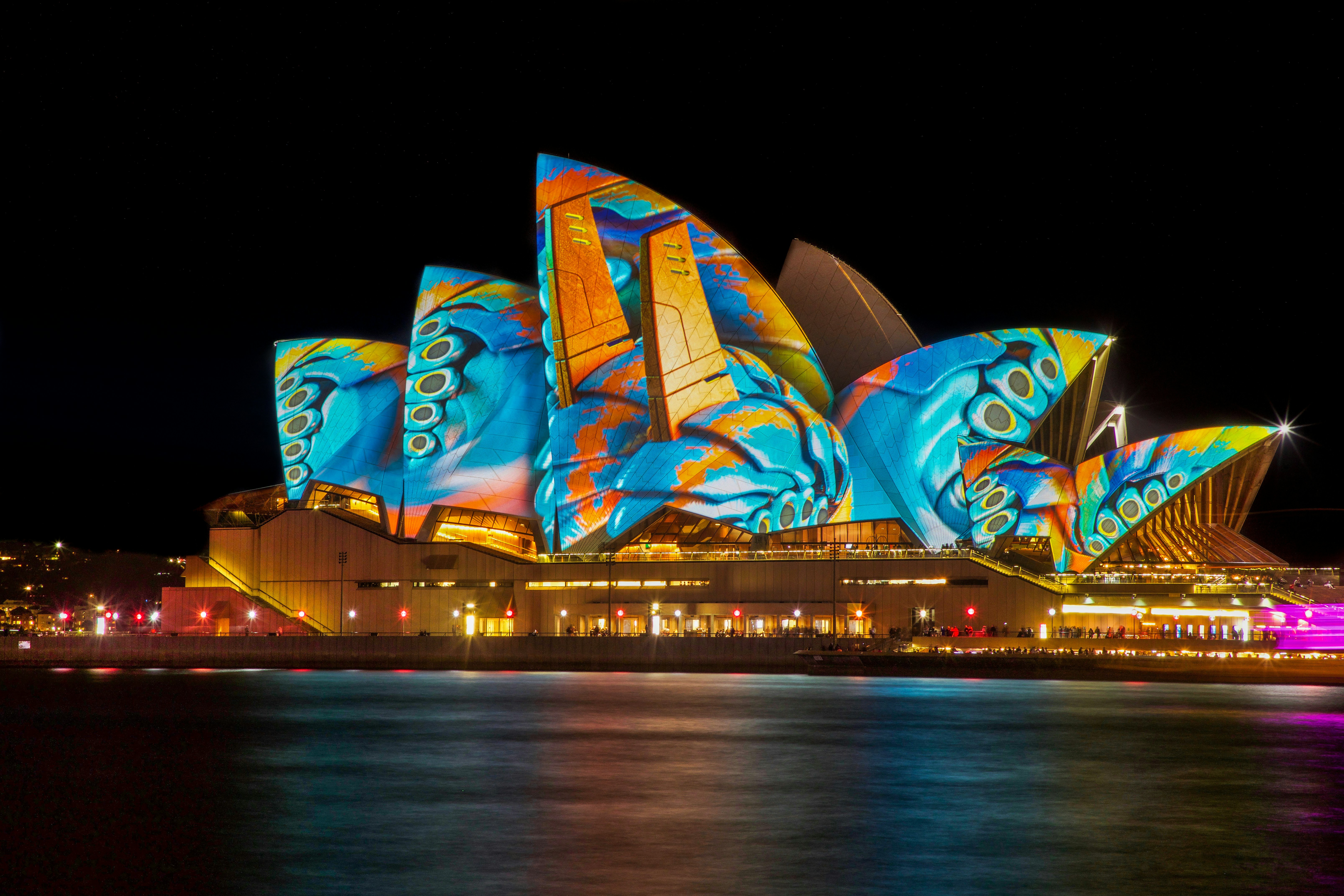 Sydney Opera House lit with colorful festival projections at night